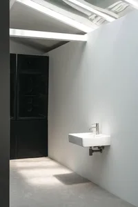 A modern bathroom with two sinks, a mirror, and a minimalist design