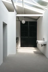 Clean and organized kitchen with two sinks, an oven, and a refrigerator, set against a neutral background