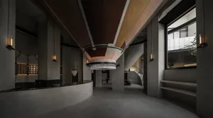 A modern lobby with a circular wooden ceiling, multiple chairs, and two dining tables, creating a warm and inviting atmosphere
