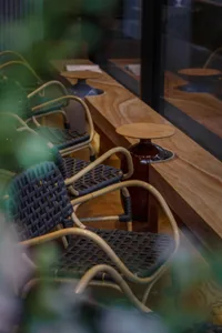 A cozy indoor seating area with multiple chairs arranged around dining tables, featuring vases and a comfortable atmosphere
