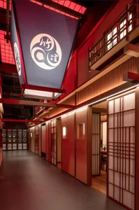 Warm and inviting Asian restaurant interior with red walls, wooden doors, and traditional design elements