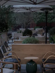 Outdoor dining area with multiple tables, chairs, and umbrellas, set in a comfortable and inviting atmosphere