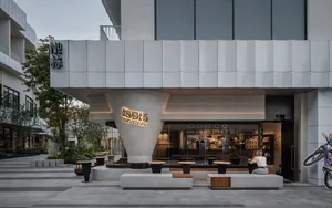 A modern Asian restaurant with a large dining area featuring several tables and chairs, with inviting and comfortable atmosphere