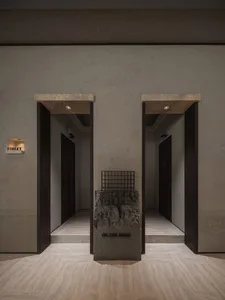 A well-lit hallway with two doors, one open and one closed, and three people standing near the open door