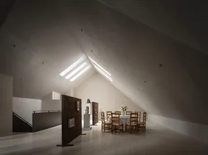 Open living area with a vaulted ceiling, dining table, chairs, and a couch, in a modern and contemporary style