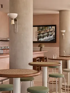 A cozy bar area with wooden tables and chairs, wine glasses, and various seating options