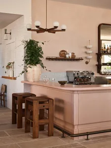 Inviting bar area with a pink countertop, chairs, and bottles, set in a restaurant