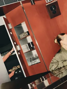 A casual kitchen scene with a woman standing in front of an open refrigerator, surrounded by wine glasses and everyday cooking items