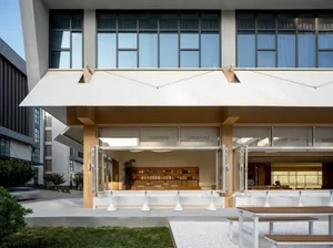 A modern building with a metal roof, featuring benches and books in a relaxed atmosphere