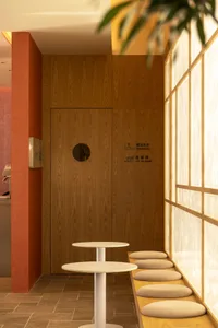 Warm and inviting room with wooden walls and floors, featuring two benches and a potted plant, with natural wood elements creating a cozy ambiance