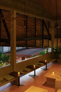A spacious interior with a high ceiling, multiple couches, chairs, and inviting atmosphere