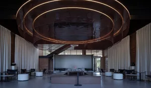 Elegant hotel lobby with a large circular table, multiple couches, and a wooden ceiling