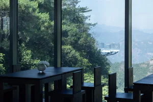餐廳內部，設有多張桌椅、花瓶，以及山景背景的用餐區