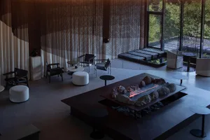 Cozy living space with a stone fireplace, chairs, and couches, creating a warm and inviting atmosphere