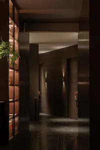 Dimly lit hallway with wooden walls and floors, featuring two doors on either side