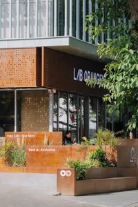 A relaxed outdoor seating area with potted plants, tables, and people enjoying their meals