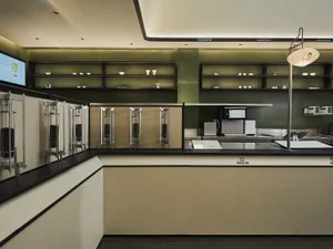 Industrial kitchen with green walls, black countertops, multiple refrigerators, and various kitchenware