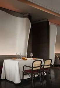 Elegant dining area with a white table, red tablecloth, and four chairs, set in a modern restaurant with a sophisticated atmosphere