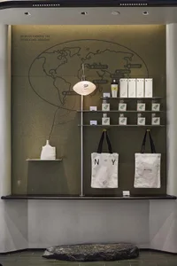 A store display featuring white tote bags, a globe, and bottles in a clean and organized setting
