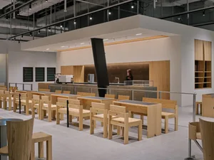 Empty restaurant interior with wooden tables and chairs, clean and well-organized, warm and inviting atmosphere