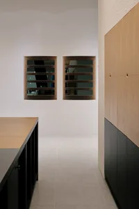 A calm and inviting kitchen with white walls, two mirrors, and cabinets, giving a sense of openness and serenity