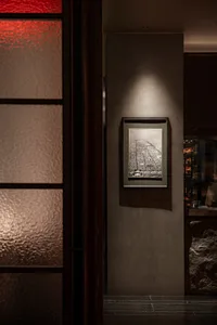城市街道夜間的黑白照片，展現歷史建築立面與人工燈光