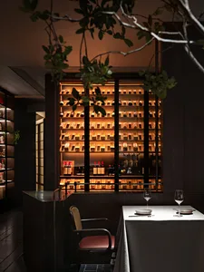 Elegant dining space with a wooden table and chairs, wine bottles, and a sophisticated atmosphere