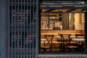 A cozy restaurant interior with wooden chairs and dining tables, creating an inviting atmosphere for a meal