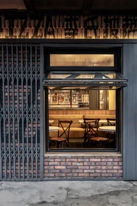 A casual dining area with white tables and varied chairs, set in a restaurant with a cozy atmosphere