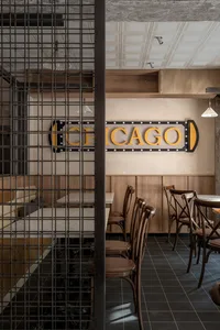 Cozy restaurant dining space with wooden walls, multiple tables, and chairs, featuring a warm and inviting atmosphere