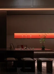 A modern dining space with a table, chairs, and a potted plant, set up for a meal or gathering, with a focus on functionality and contemporary design elements