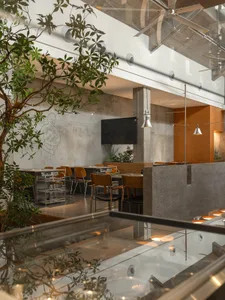 A well-lit dining area with multiple tables and chairs, modern restaurant design with a focus on functionality and comfort