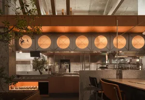 Warm and inviting restaurant interior with round decorative elements, potted plants, and modern appliances