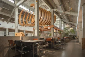 A well-lit restaurant interior with modern design, multiple dining tables, and comfortable seating options