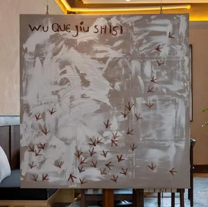 A dimly lit room with a painting of birds on the wall, two chairs, and a potted plant, creating a cozy atmosphere