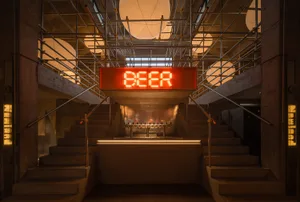 Casual industrial bar with beer taps, wooden accents, and a large sign reading Beer