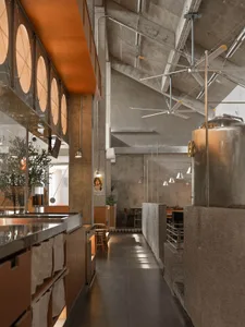 A modern restaurant space with a large dining table, chairs, and potted plants, surrounded by concrete walls and an inviting atmosphere