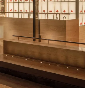 A sophisticated interior space with natural light, featuring red birds on display and elegant surroundings