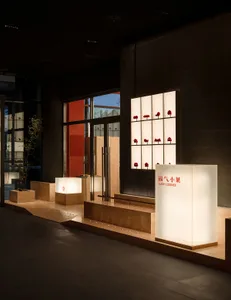 牆上掛著紅燈籠的溫馨展示空間，木製長椅，營造舒適氛圍