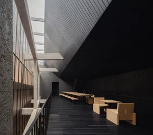Long modern hallway with wooden benches lining both sides, providing seating options and a warm inviting touch