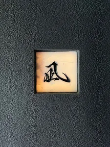 A black background with a white square containing Chinese characters in an oriental design, suggesting a cultural and artistic theme