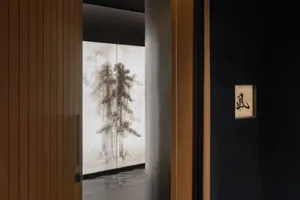 A calm and inviting hallway with a wooden doorframe, two painted trees on the wall, and a sense of serenity