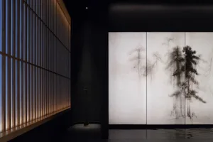 A serene room with a tree mural on the wall, a vase, and a calm atmosphere
