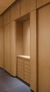 A calm and organized wooden hallway with a built-in cabinet and two doors, featuring a warm and cozy atmosphere