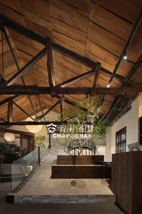A warm and inviting interior space with a large wooden staircase, potted plants, and a modern aesthetic