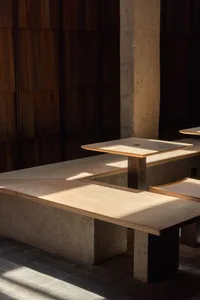 A cozy lobby with several wooden tables and benches, inviting for social gatherings or relaxation