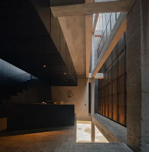 Modern open space with a black countertop, clock on the wall, and two staircases, with a focus on functionality and simplicity
