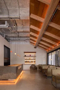 Warm and inviting restaurant interior with wooden beams on the ceiling and walls, multiple chairs, and dining tables