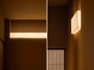 Dimly lit room with brown walls, lights on the wall, and a doorway, creating a cozy atmosphere