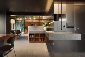 Modern kitchen with a countertop island, sink, and two chairs, featuring a well-organized and modern atmosphere